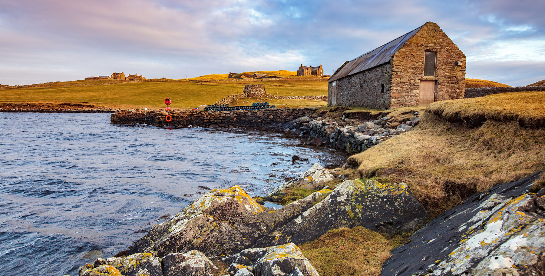 Lunna Kirk (Lunna Ness), boat shelter and Lunna House, Norwegian headquarters during World War II in the background - Photo: Shutterstock.com